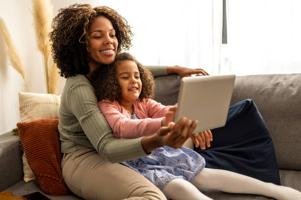 istock Mother and daughter using digital tablet for video call 1437181890