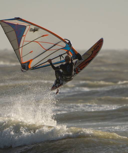 windsurfer wykonujący akrobacje w wodzie - windsurfing zdjęcia i obrazy z banku zdjęć