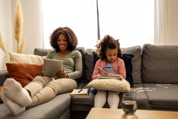 istock Mother and daughter sitting on the sofa 1437183280