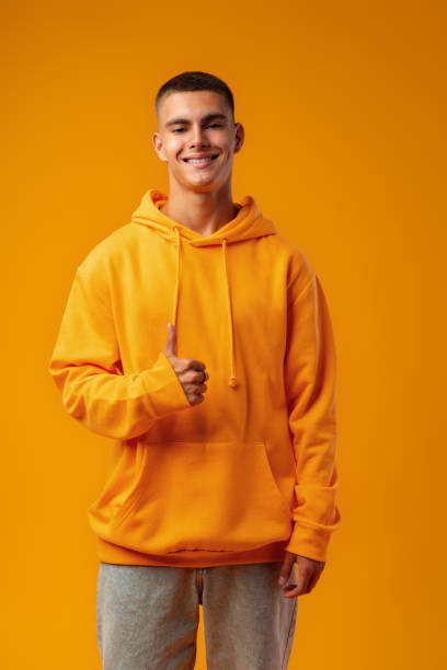 istock Happy young man gesturing OK sign against yellow studio background 1437183535