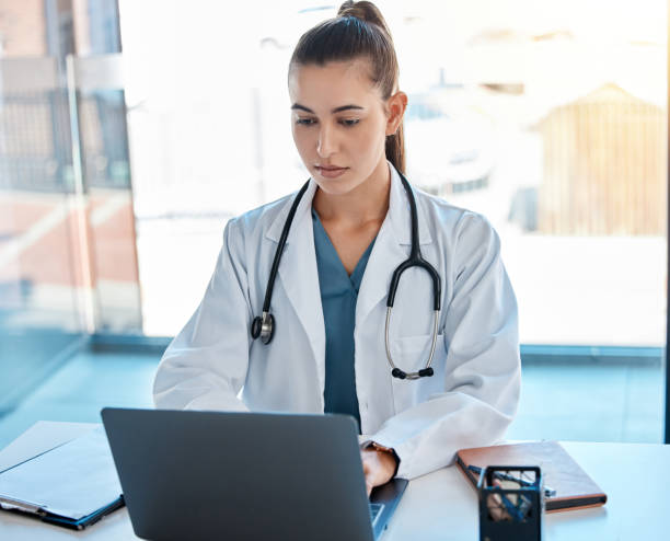 istock Doctor typing on a laptop in an office writing a proposal or on a video call using telemedicine. Young healthcare professional or GP using the internet for research or online consultation 1437187293