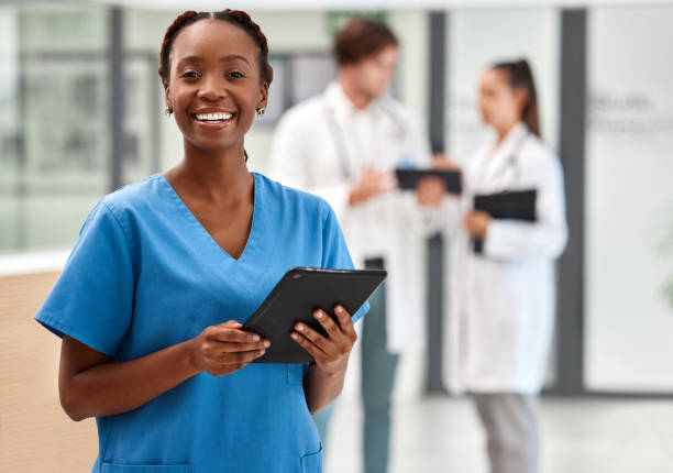 retrato de una doctora feliz trabajando en una tableta digital y sonriendo mientras trabaja en un hospital. enfermera negra que realiza investigaciones médicas y de atención médica en internet o en línea en el trabajo en una clínica - portrait doctor paramedic professional occupation fotografías e imágenes de stock