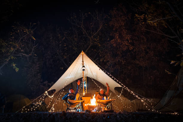 istock Family sitting by camp fire at night 1437188782