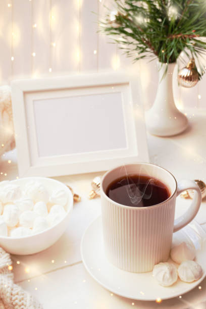 istock Winter, Christmas, New Year decorations composition, concept, background. White Mug, cup of tea, coffee, steam, meringue, knitted plaid. Christmas lights. Christmas mood morning. Christmas greeting card. 1437188859