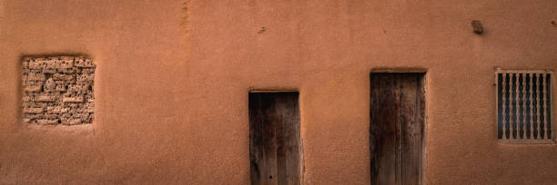 Abstract geometry of southwestern Adobe earth tone stucco wall with doors and windows