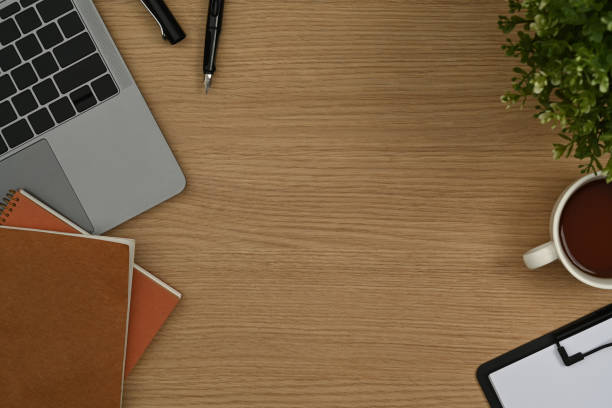 istock Simple workplace with laptop computer, notepad, clipboard and coffee cup on wooden office desk. 1437192178