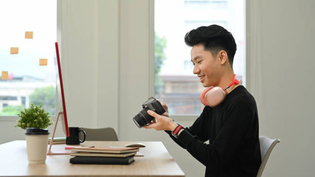 istock Side view of handsome male photographer working in bright modern creative studio. 1437192220