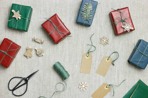 istock Christmas and New Year gift boxes, zero waste, eco friendly packaged gifts in kraft colored paper, green fir tree branches on table, preparation colorful xmas presents, eco christmas concept 1437192461