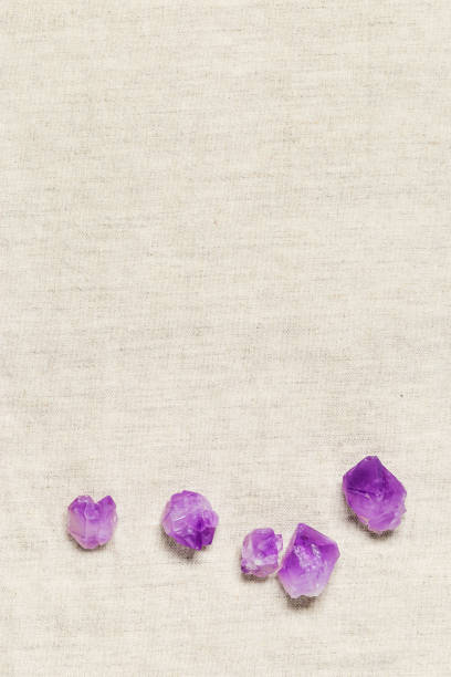istock Flat lay purple amethyst crystals on fabric background with copyspace. Amethyst stone magic and  healing crystal, alternative medicine. Top view natural gemstone rocks, quartz mineral 1437194298