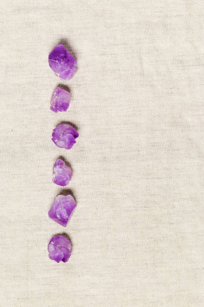 istock Flat lay purple amethyst crystals on fabric background with copyspace. Amethyst stone magic and  healing crystal, alternative medicine. Top view natural gemstone rocks, quartz mineral 1437194309