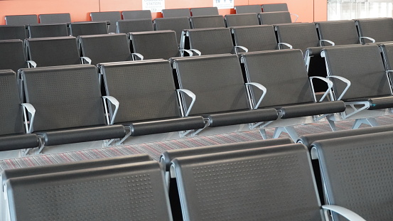 Empty airport terminal lounge. Empty airport seating - typical black chairs in boarding waiting