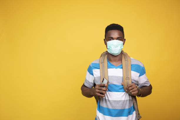 istock Young African male with a backpack wearing a facemask - COVID-19 1437197961