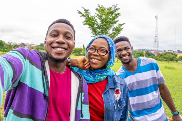 istock Group of African friends with facemasks taking a selfie in a park 1437198421