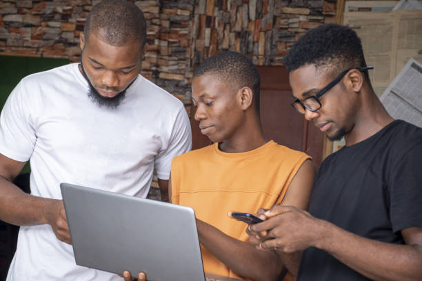 istock Group of young African males discussing a project while using their laptop and phones 1437198626