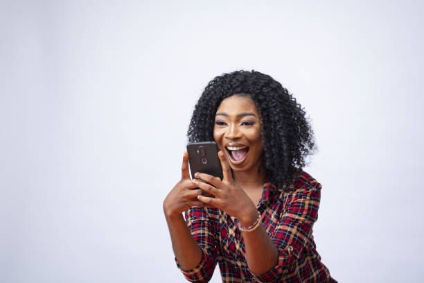 istock Happy young African female using her phone and feeling excited about something 1437198664