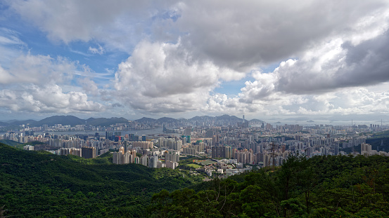 A breathtaking view of Hong Kong cityscape and mountains under the cloudy sky