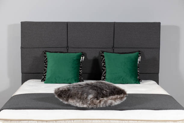 istock Modern bed with gray upholstery and a fluffy pillow 1437200763
