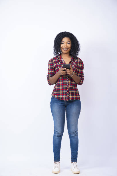 istock Vertical shot of a pretty black woman smiling while using her phone 1437201334