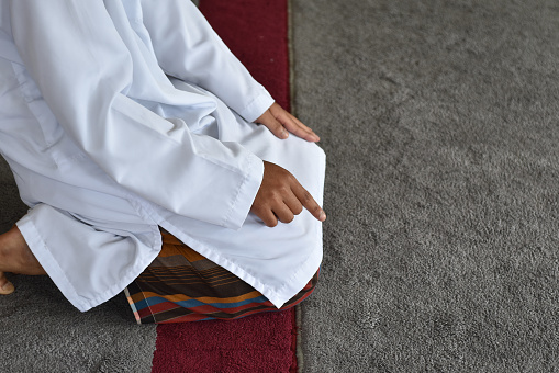 Muslim men praying in Tashahhud posture. Islamic concept