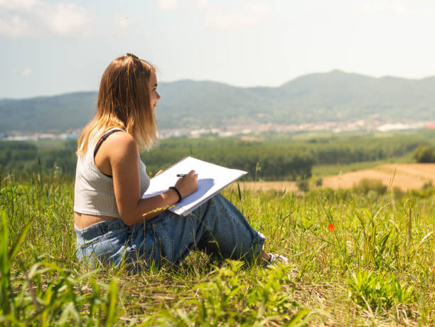 istock Caucasian female sitting and drawing in nature 1437201876
