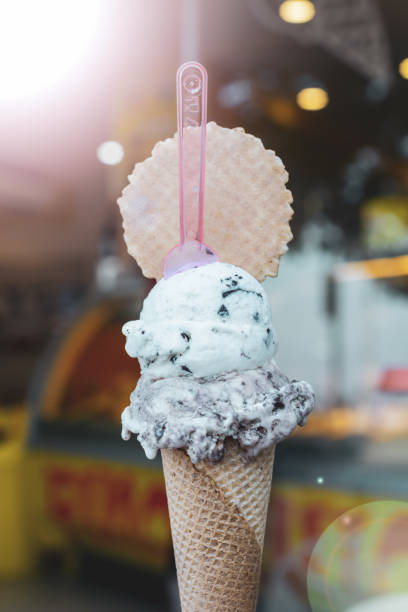 istock Vertical selective focus shot of mint chocolate chip ice cream scoops on a cone with a spoon 1437202571