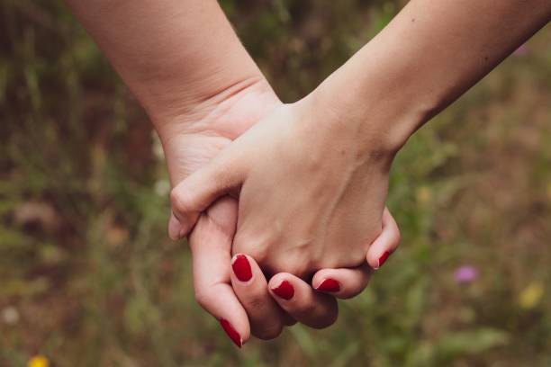 istock Females romantically holding hands in the woods 1437203545
