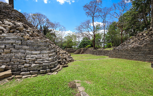 Toledo District, Belize – June 10, 2019: A path allows visitors to walk amongst the preserved ruins at Lubaantun Mayan Archaeological Site in Southern Belize.