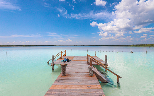 Tulum, Quintana Roo, Mexico – August 29, 2019: A scenic pier stands above emerald blue waters at Kaan Luum Lagoon.