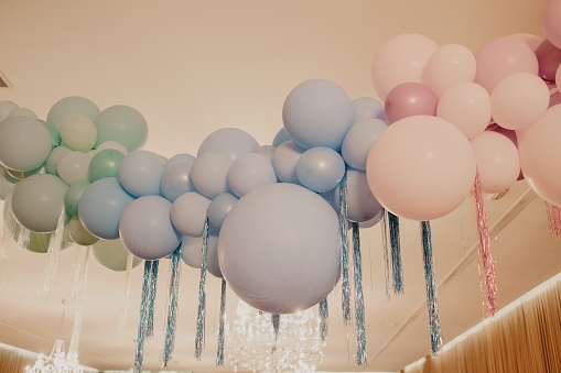 A low angle shot of colorful balloons decoration hanging from the ceiling