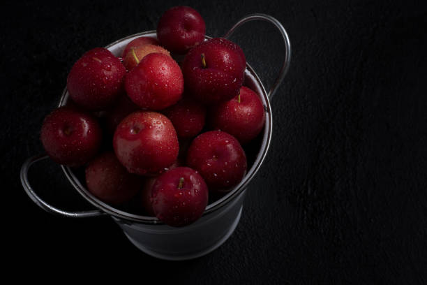 黒い背景にバケツの中の新鮮な赤いリンゴのオーバーヘッドショット - healthy eating red above studio shot ストックフォトと画像