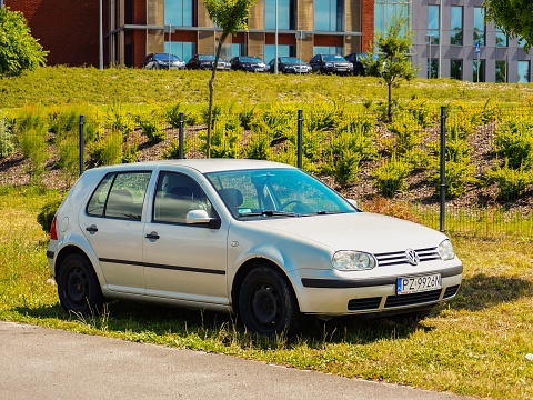 Gadki, Poland – June 24, 2014: Silver Volkswagen Golf parked on green grass by a road