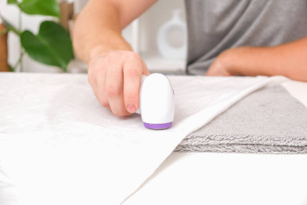 istock man removes fabric pills using lint shaver. 1437207267
