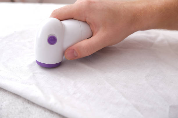 istock man removes fabric pills using lint shaver. 1437207275