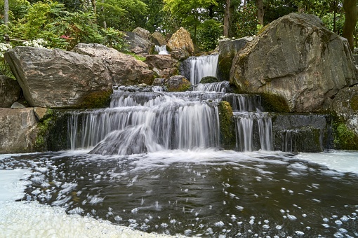 The waterfall coming through the rocks in Kyoto Garden in Kensington, UK
