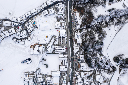 An aerial view of a resort town in Austria surrounded by snowy mountains
