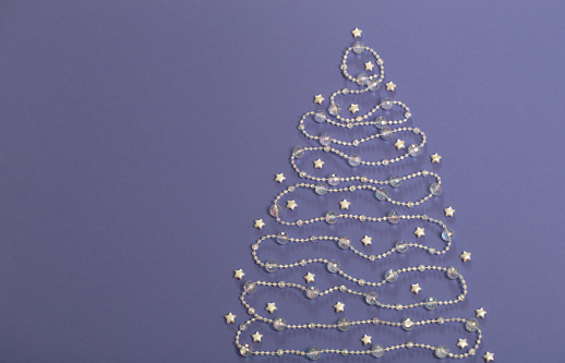 glass beads laid out in  shape of  Christmas tree on purple background