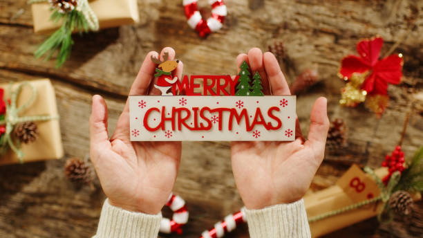 istock Hand Holding Merry Christmas text on presents background 1437209060