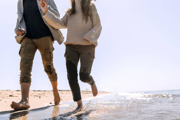 istock Unrecognizable couple running by the sea together 1437214924