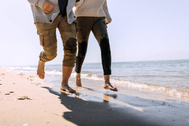 istock Unrecognizable couple running by the sea together 1437214940