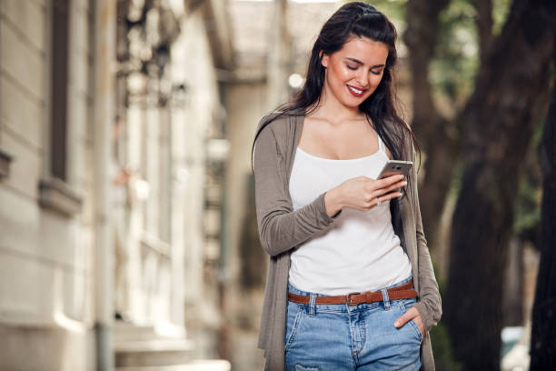 istock Young cute female using smartphone on the street. 1437216131