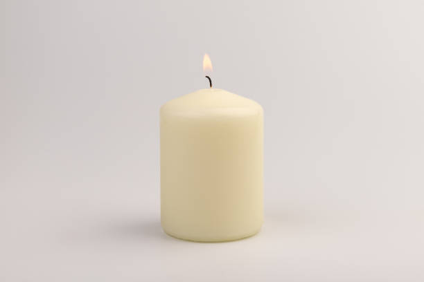 istock Burning white wax candles on white background. 1437216170