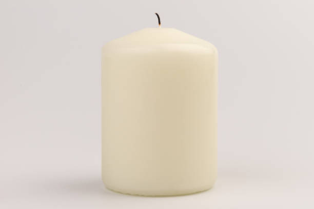 istock Burning white wax candles on white background. 1437216181