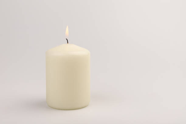 istock Burning white wax candles on white background. 1437216196