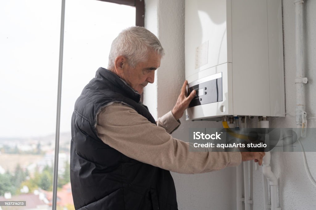 Senior Man Controlling The Boiler Examining Stock Photo