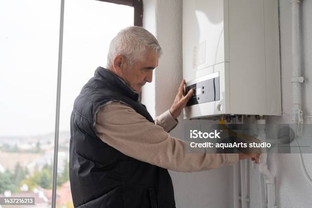 Senior Man Controlling The Boiler Stock Photo - Download Image Now - Examining, Fire - Natural Phenomenon, Gas Boiler