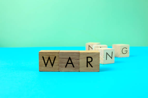 inscription war scorched on wooden cubes and nearby letters about the warning of danger. the concept of warning and further transition to war. precariousness stock photo