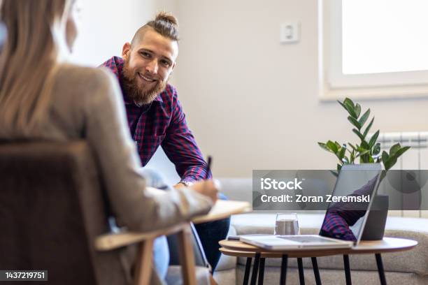 Female Psychologist Talking To Young Man During Session Stock Photo - Download Image Now