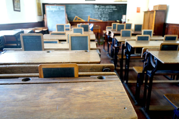 istock Old historical classroom with wooden desks and chalkboards 1437219905
