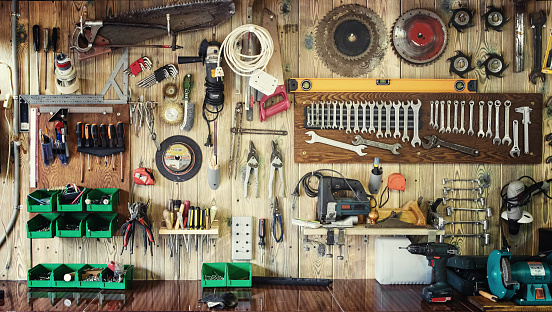 Varias herramientas cuelgan en una pared de madera en un taller photo