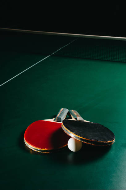 istock Two ping pong rackets and a ball are on the green game table 1437220992